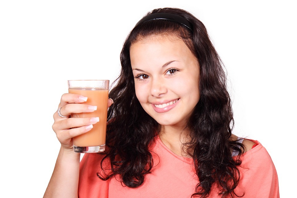 girl smiling with a glass of juice